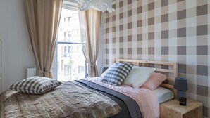 A bedroom with a bed, curtains, a nightstand, and a lamp. - Dream Holiday-Apartamenty Chmielna Park (Gdansk)