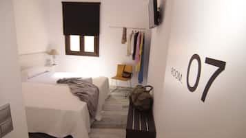 Cozy retreat with a single bed, TV, and ample storage.