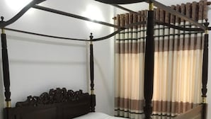 Una cama con dosel de madera oscura y ropa de cama blanca.