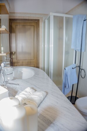 Apartamento, 2 quartos | Banheiro | Chuveiro, chuveiro com efeito de chuva, bidê, toalhas de banho