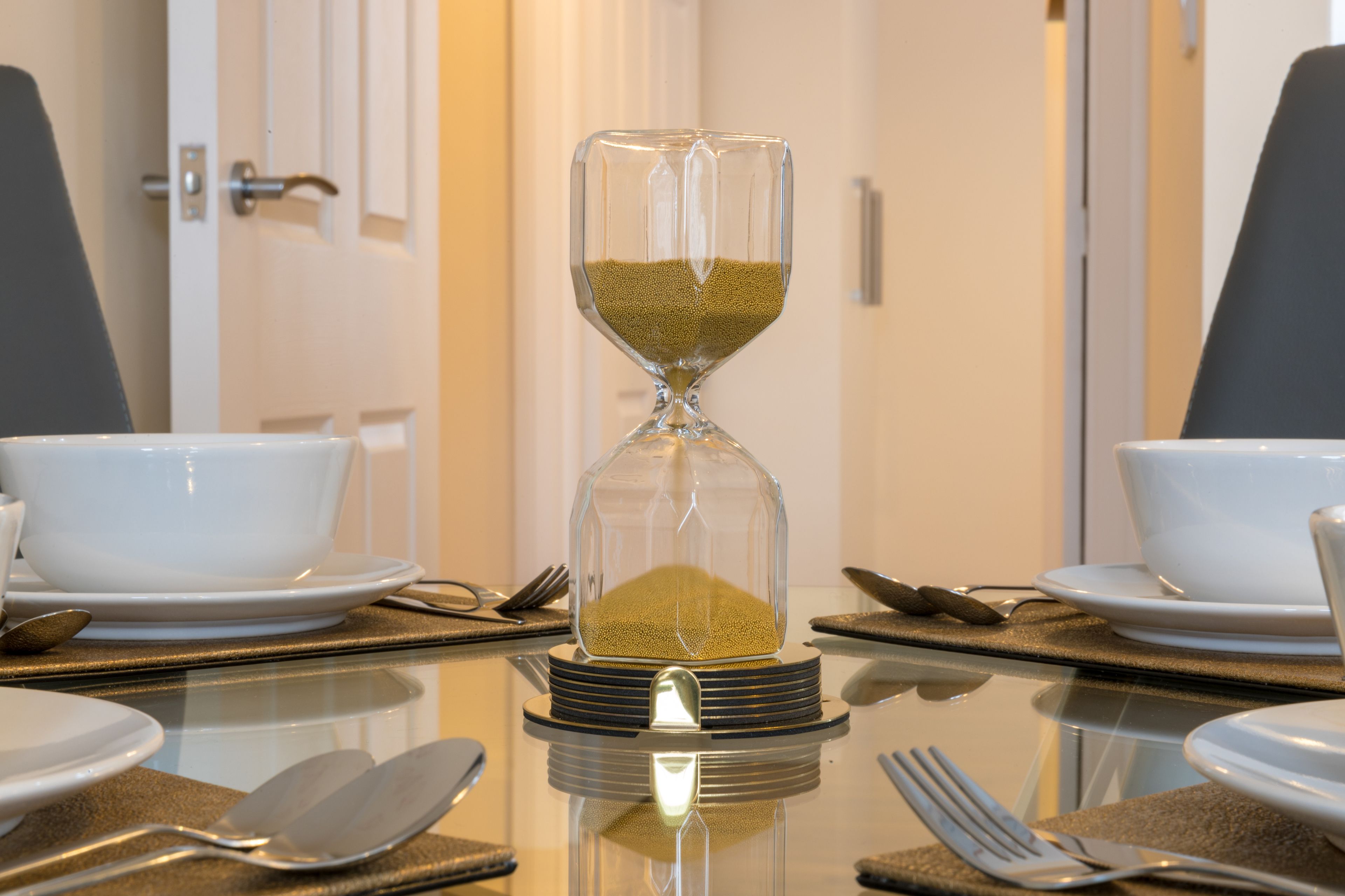 Ein gedeckter Tisch mit einer Sanduhr in der Mitte.
