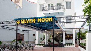A hotel entrance with a sign reading "SILVER MOON," a covered bike parking area, and a staircase leading to the entrance. - Silver Moon Villa Hoi An (Da Nang)
