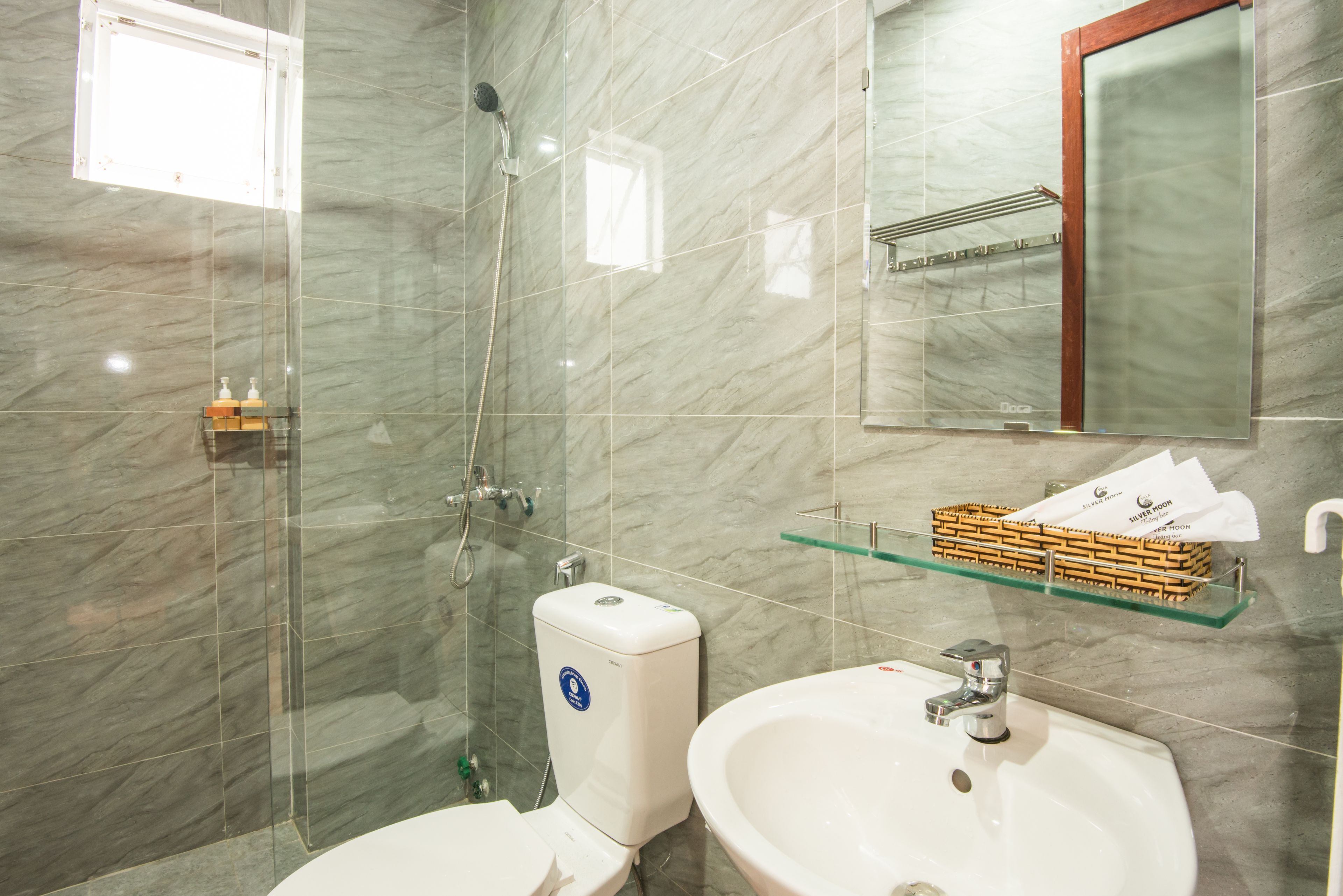 A bathroom with a toilet, sink, and shower.