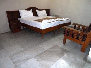 Cozy retreat with a simple wooden bed and comfortable chair.