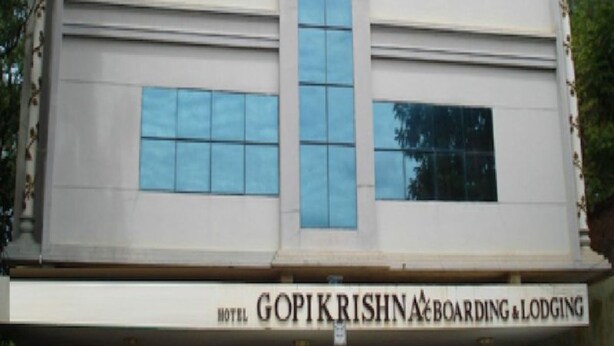 A hotel building with a sign reading "GOPIKRISHNA BOARDING & LODGING".