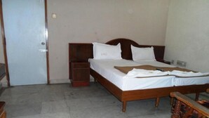 A bedroom with a wooden bed, a nightstand, and a bench with a storage compartment.