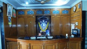 A reception desk with a wooden finish, a ceiling fan, and a clock on the wall.