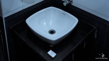 Un baño con un lavabo blanco, un espejo y un perchero para toallas.