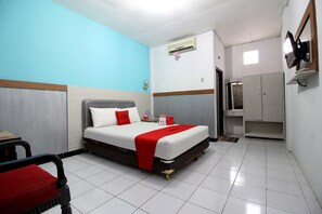 Une chambre d’hôtel équipée d’un lit, d’une chaise, d’une armoire et d’un appareil de climatisation.