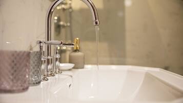 A bathroom sink with a chrome faucet and running water.