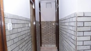 Un passadís estret amb parets revestides de rajoles i un sòl de marbre.