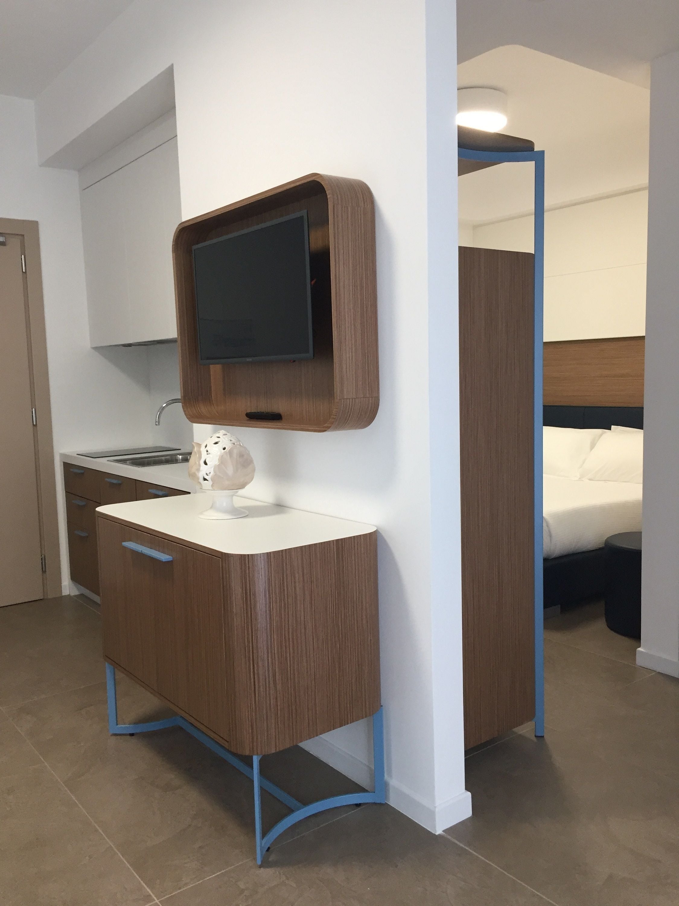 Uma casa de banho moderna com toucador de madeira, espelho e sanita integrada.