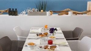 A breakfast table with various food items and a decorative plant arrangement. - M&F Hotel (Gallipoli)