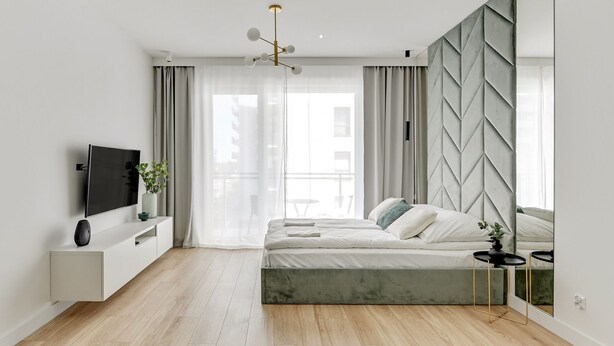 A modern bedroom with a bed, a TV, and a mirror. - Grand Apartments - Bastion Wałowa (Gdansk)