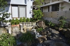 A garden with rocks, plants, and a wooden fence.