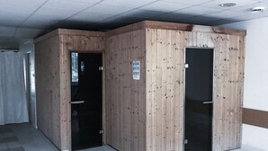 Une pièce avec un sol carrelé, des murs en bois et deux portes.