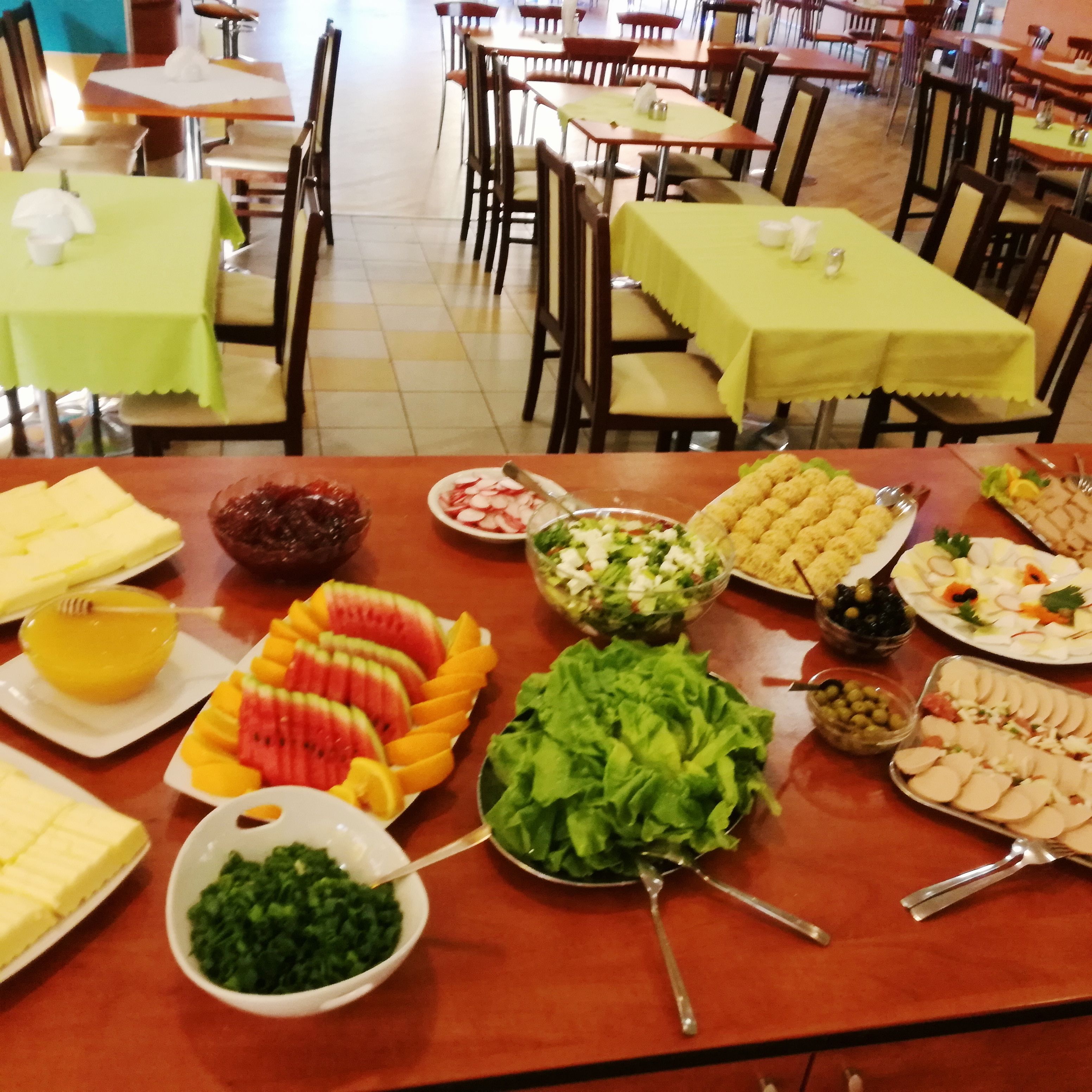 A buffet table with various food items and a salad.