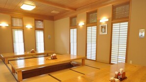 Una tipica stanza giapponese con pavimento in tatami, un tavolino in legno e pareti divisorie scorrevoli in carta di riso.