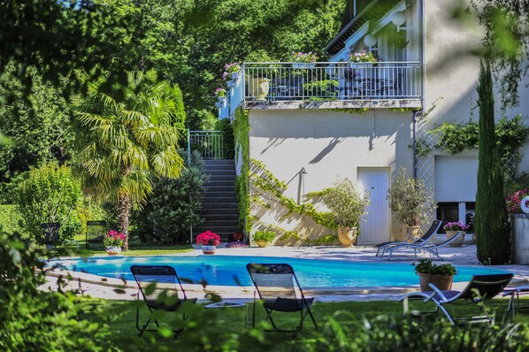 Outdoor pool, a natural pool, open 9:30 AM to 8 PM, pool loungers