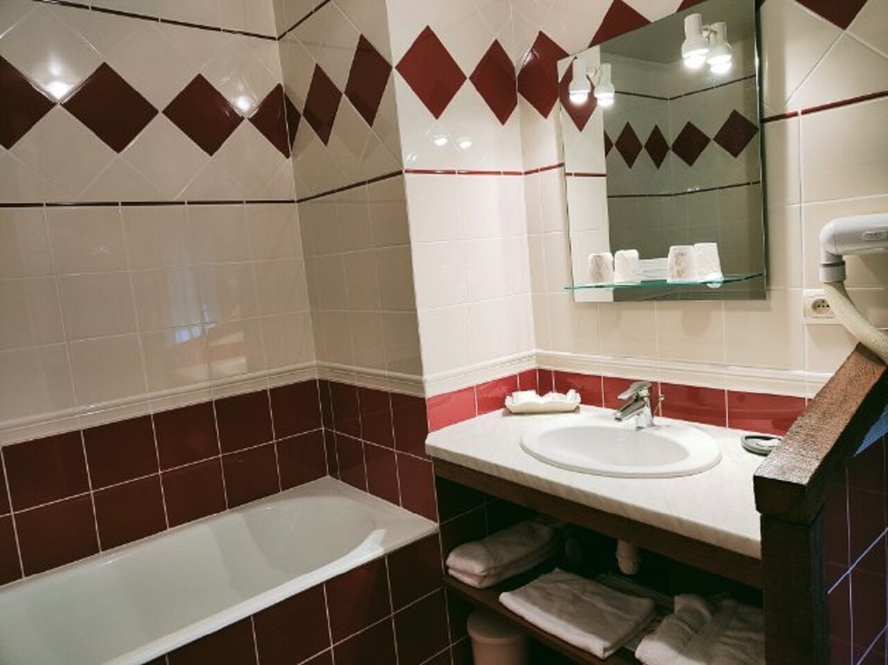 Un baño con bañera, lavabo y espejo.
