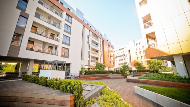 A modern apartment building with multiple balconies, a rooftop garden, and a wooden deck area. - Grand Apartments - Modern Old Town (Gdansk)