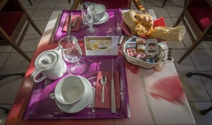 Una bandeja de desayuno con tetera, tazas, vaso, cuchillo, cuchara y una cesta de pan, además de un menú.