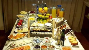 Une table de buffet proposant une variété d’aliments, notamment des viandes, des fromages, des fruits et des boissons.