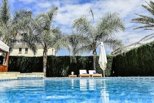 Una piscina al aire libre, tumbonas