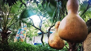 Una escultura grande y de forma peculiar en un exuberante jardín.