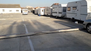 Un espace de stationnement où sont garés plusieurs camping-cars et remorques.