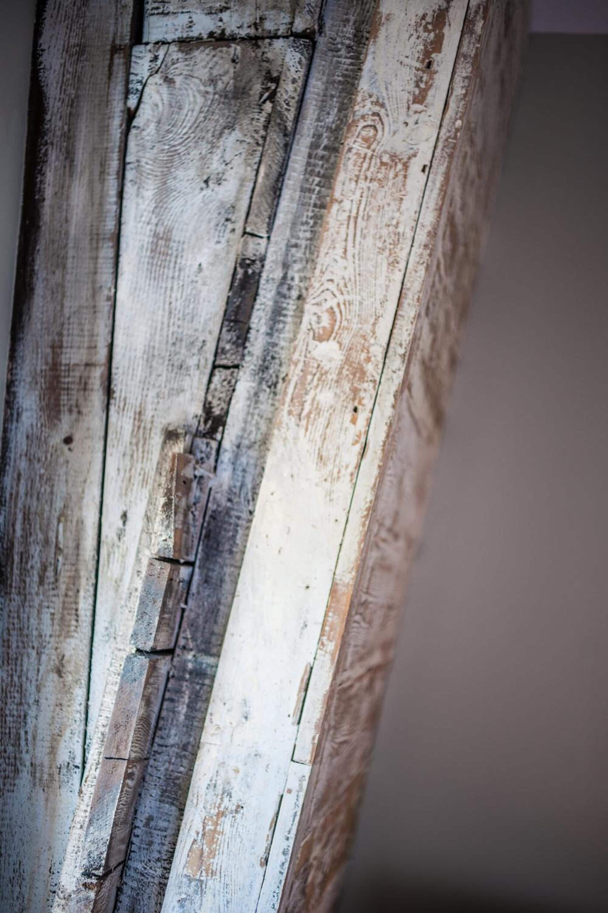 A close-up of a weathered wooden surface with visible grain and texture.