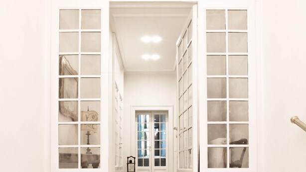 A hallway with white doors and a marble floor leading to a room. - B&B La Foresteria (Milan)