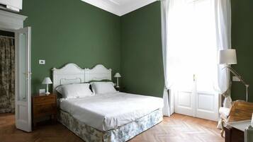 Une chambre à coucher avec un lit, des tables de chevet, une lampe et une fenêtre avec des rideaux.
