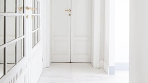 A hallway with a white door and a large window on the right. - B&B La Foresteria (Milan)
