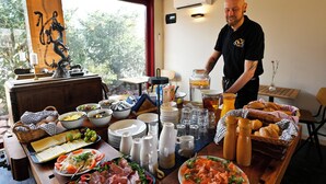 Een buffetopstelling met diverse gerechten, borden en bestek.