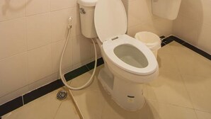 Un baño con inodoro, bidé y lavamanos.