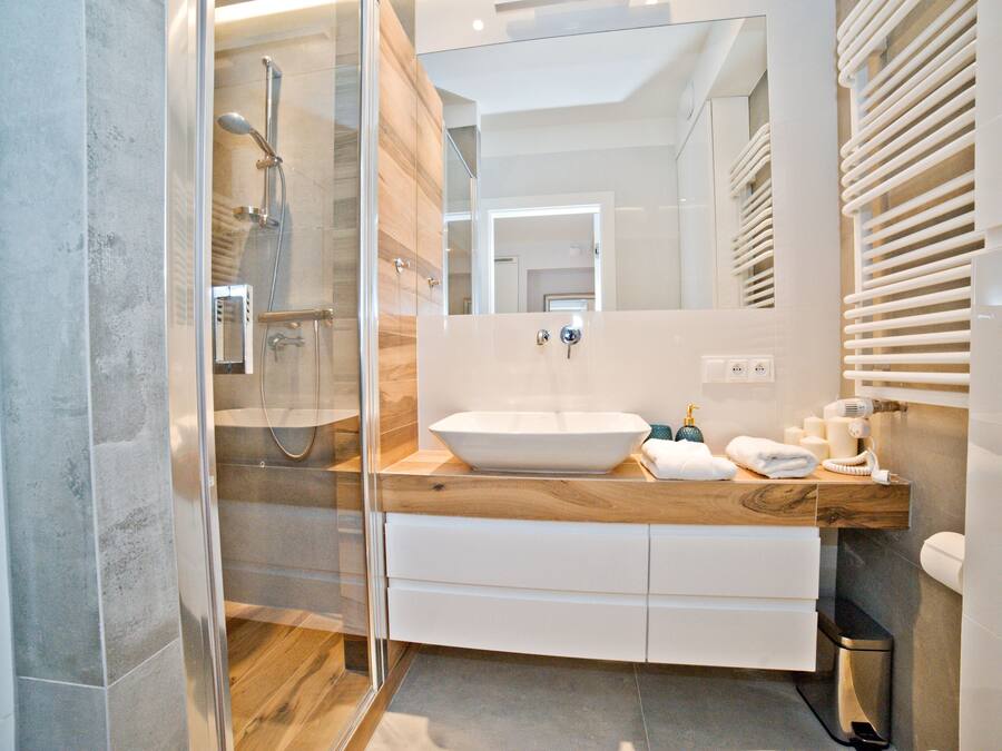Deluxe studio suite | Badkamer | Een douche, een haardroger, handdoeken, zeep