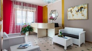 Una sala de estar moderna con un sofá blanco, una mesa de centro y una planta en maceta.