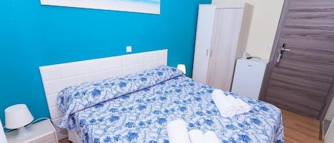 Une chambre à coucher avec un lit, une table de chevet, une armoire et une porte.