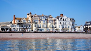 Une rangée de bâtiments situés en bord de mer, avec une plage au premier plan.