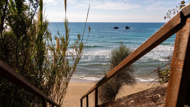 A wooden staircase leading to a sandy beach with ocean views. - Villa Meliti (Corfu)