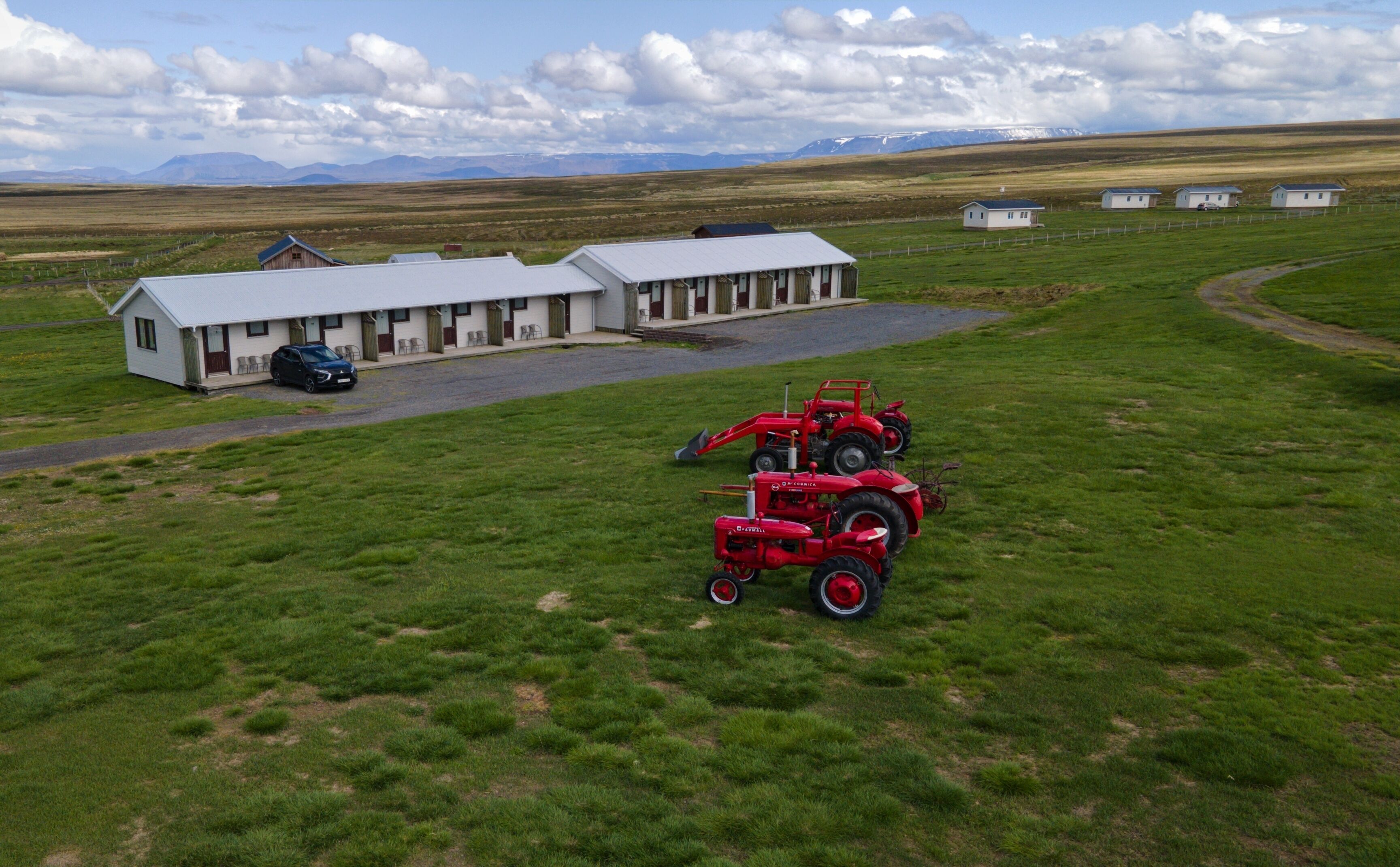 Un entorno rural con un edificio grande que parece un hotel o una posada, con varias habitaciones y un patio central.