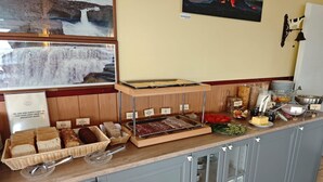 A breakfast buffet with various food items and a sign instructing guests not to take food from the breakfast room.