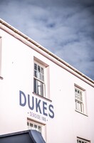 Exterior del Dukes Seaside Inn, con un cartel llamativo que muestra el nombre del hotel.
