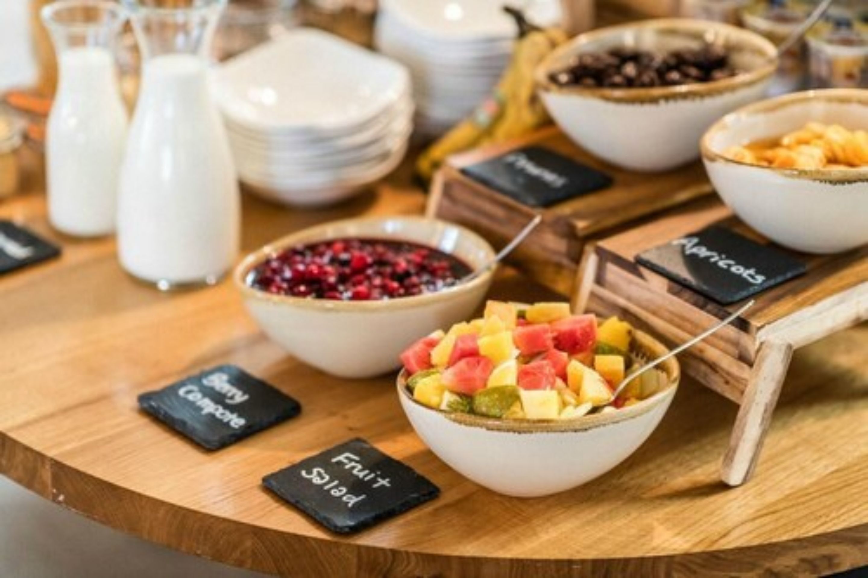 A breakfast buffet with various fruit and cereal options.