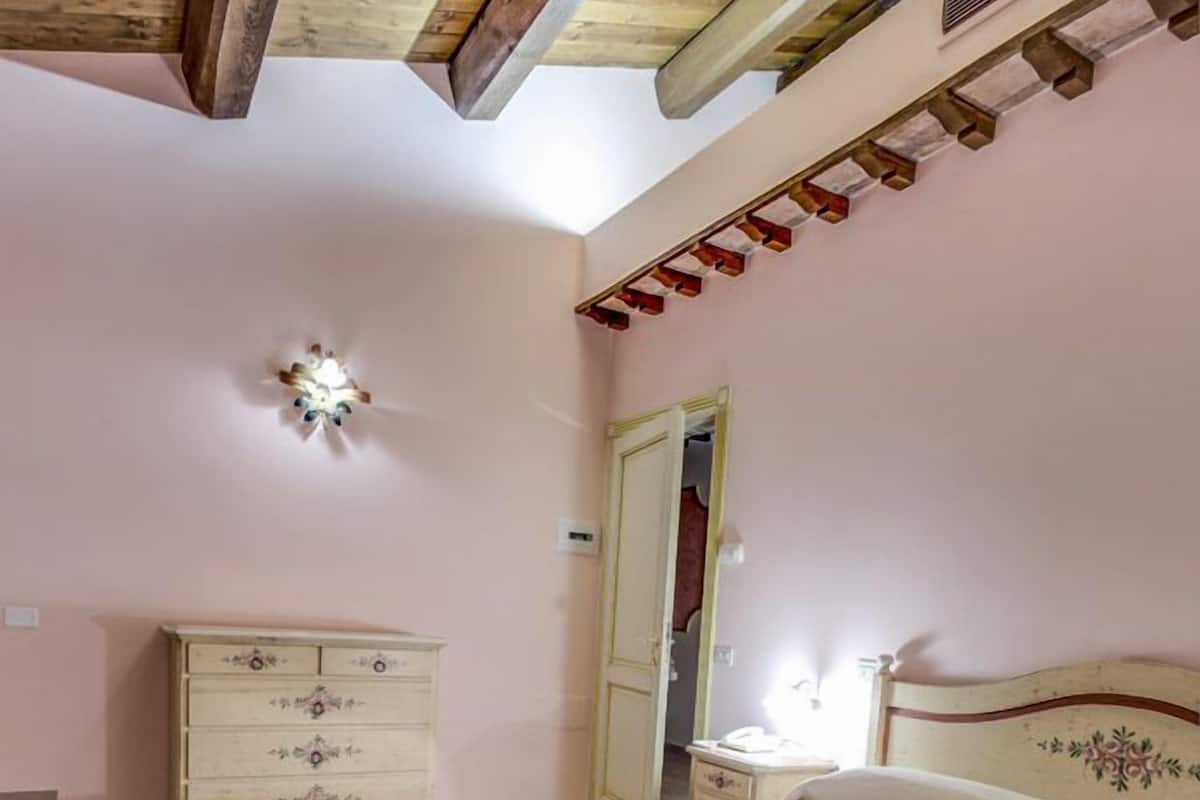 A bedroom with a wooden bed, a dresser, and a wardrobe.