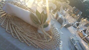 Une table dressée pour un repas, avec un set de table en fibres tressées, une serviette pliée et de la verrerie transparente.