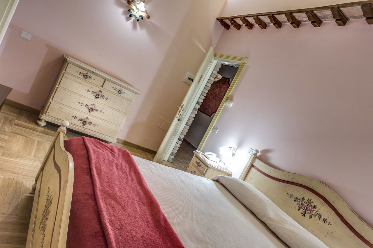 Ein Schlafzimmer mit einem hölzernen Bett, einem Schminktisch, einem Spiegel und einem kleinen Nachttisch.