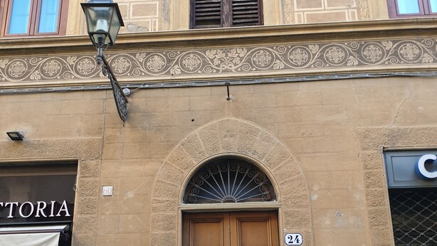 A building facade with a large wooden door, a sign reading "COTORIA", and a street number "24". - Soggiorno Annamaria (Florence)