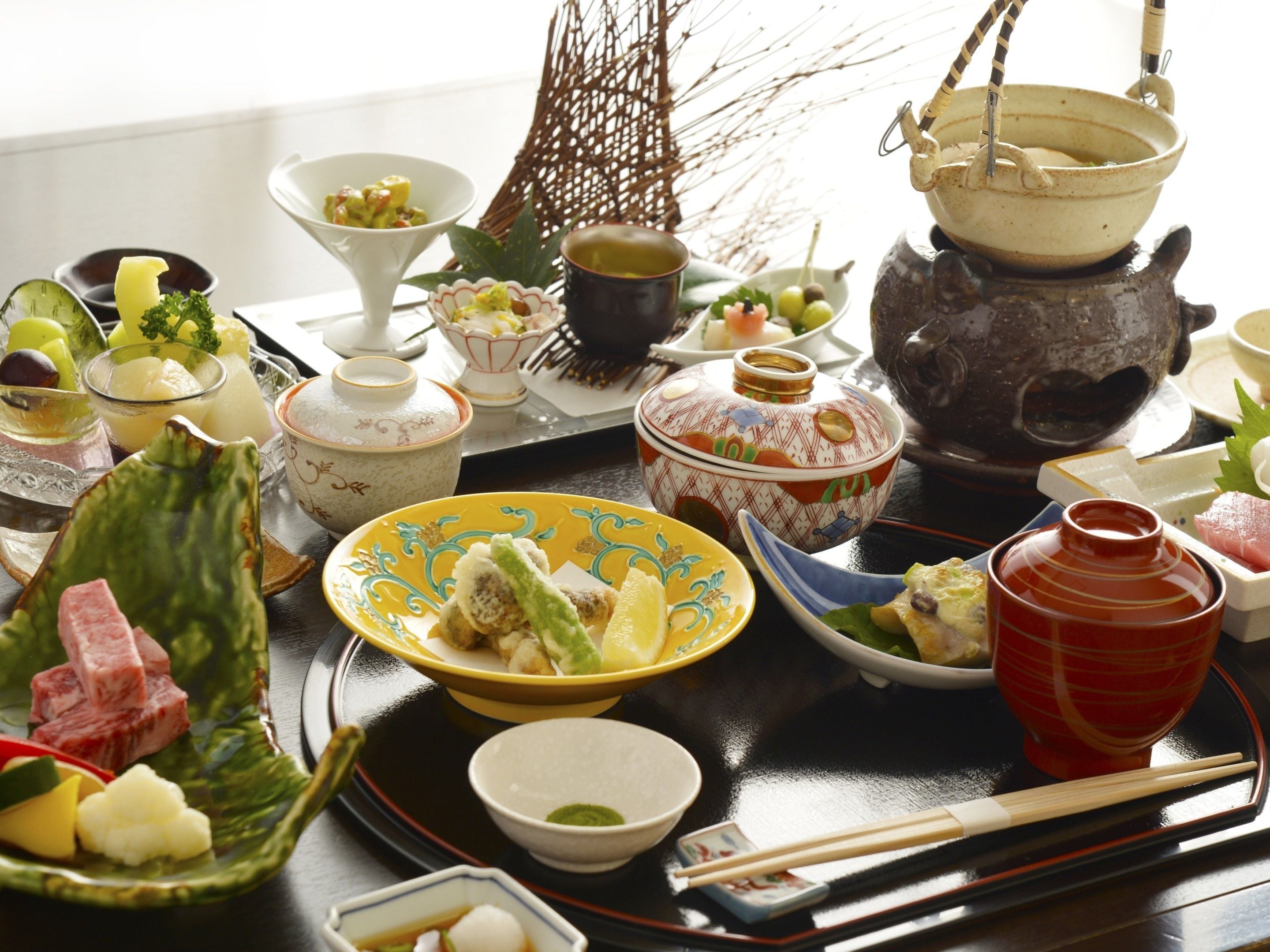 Eine traditionelle japanische Mahlzeit mit verschiedenen Gerichten und Besteck auf einer Schale.